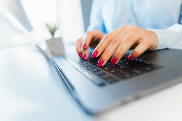 Frauenhände mit heller Maniküre tippen auf einer Laptop-Tastatur — Stockfoto