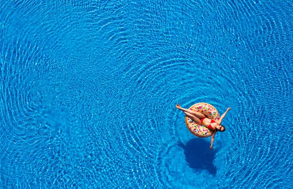 Vista aérea de una mujer en bikini rojo acostada en una dona en la caca — Foto de Stock