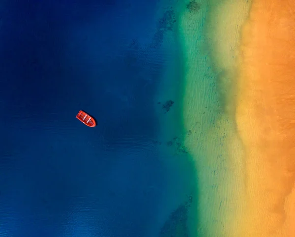 Vista aérea de um barco vermelho solitário ancorado ao largo da costa de Las T Imagens De Bancos De Imagens Sem Royalties