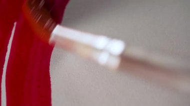 Kırmızı suluboya ile beyaz kağıda boya fırçası çiziyorum. Doku ve arkaplan