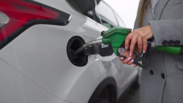 La mujer llena gasolina en su auto en un primer plano de la gasolinera. Movimiento lento — Vídeo de stock