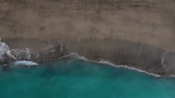 Blick von oben auf den schwarzen Wüstenstrand am Atlantik. Küste der Insel Teneriffa. Drohnenaufnahmen von Meereswellen, die die Küste erreichen — Stockvideo