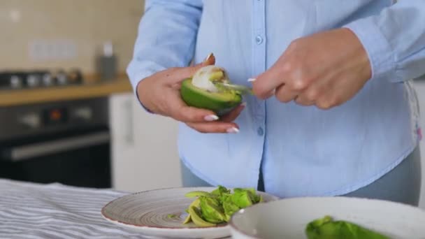 Preparation avocados for use - separates the pulp from the skin with a spoon — Stock Video