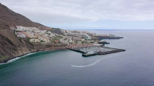 Вид с воздуха на Los Gigantes, вид на гавань и город. Лодка входит в пристань. Тенерифе, Канарские острова, Испания — стоковое видео