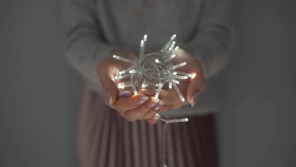Vrouw houdt witte kerst slinger in handen close-up — Stockvideo