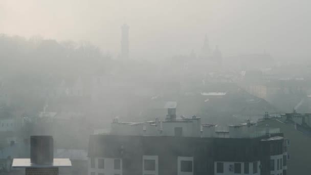 Lviv történelmi központja sűrű ködben. Épületek és háztetők sziluettjei. Ukrajna — Stock videók
