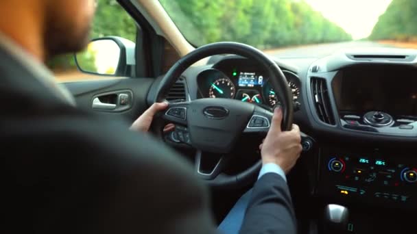 Uomo alla guida di una macchina sulla strada con il tempo soleggiato. Vista da dietro il conducente — Video Stock