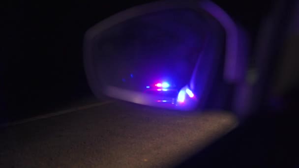 Luces parpadeantes de la policía reflejadas en el espejo retrovisor de un coche por la noche — Vídeo de stock