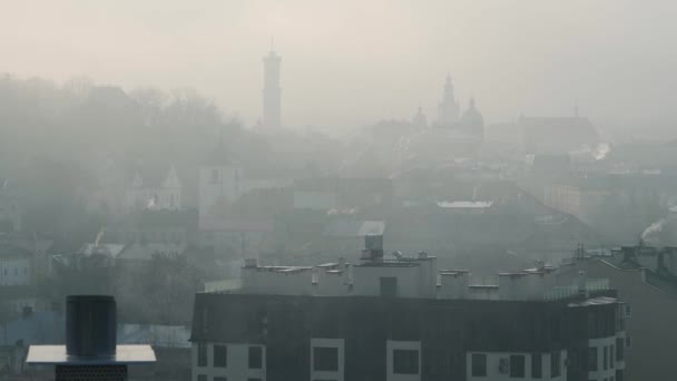 Lviv 'in yoğun sis altındaki tarihi merkezinin zamanı. Binaların siluetleri ve evlerin çatıları. Ukrayna — Stok video