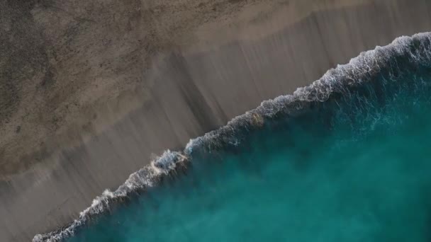 Blick von oben auf den schwarzen Wüstenstrand am Atlantik. Küste der Insel Teneriffa. Drohnenaufnahmen von Meereswellen, die die Küste erreichen — Stockvideo