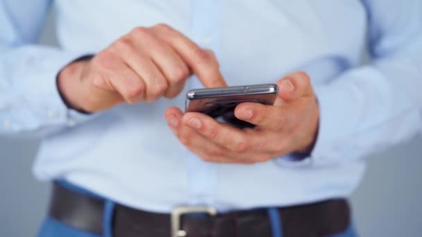 Hombre vestido formalmente usando smartphone para servir en internet de cerca — Vídeo de stock