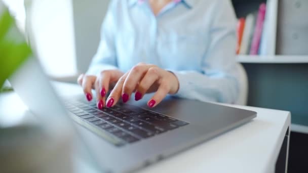 Parlak manikürlü kadın elleri dizüstü bilgisayarın klavyesinde yazı yazıyor. — Stok video