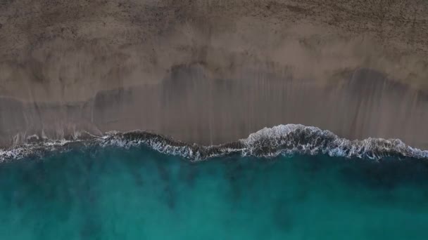 Top view of the desert black beach on the Atlantic Ocean. Coast of the island of Tenerife. Aerial drone footage of sea waves reaching shore — Stock Video