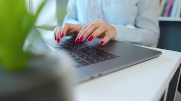 Vrouwelijke handen met heldere manicure typen op een laptop toetsenbord — Stockvideo