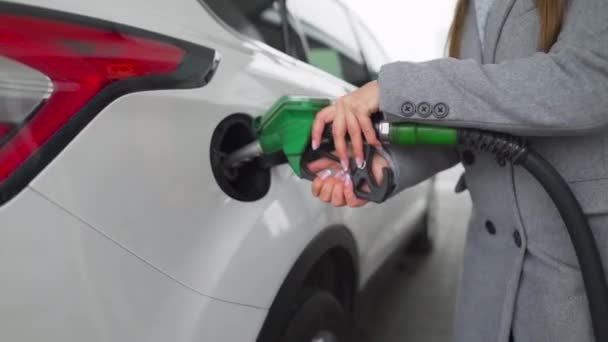 Femme remplit l'essence dans sa voiture à une station-service gros plan — Video