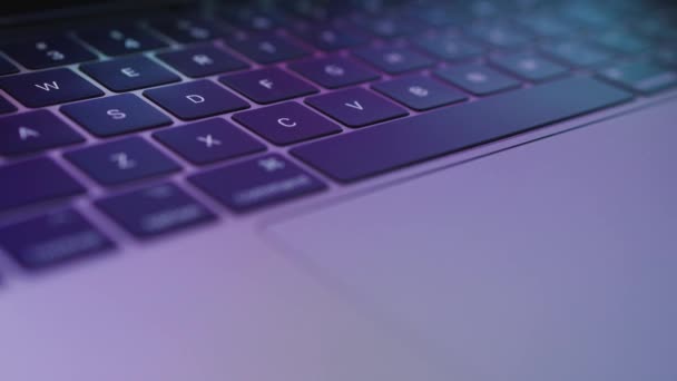 Teclado de laptop close-up com destaques multicoloridos nele. Reflexão muito turva do que é exibido no monitor — Vídeo de Stock