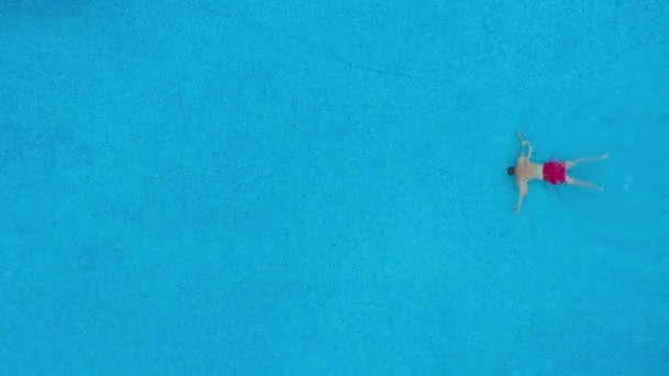 Θέα από την κορυφή όπως ένας άνθρωπος κολυμπά κάτω από το νερό στην πισίνα. Αργή κίνηση — Αρχείο Βίντεο