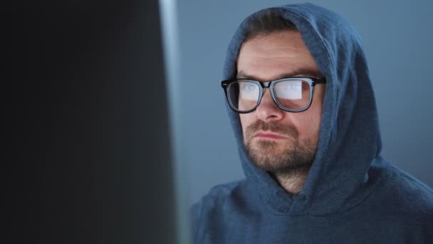 Άντρας χάκερ με κουκούλα και γυαλιά που δουλεύει σε υπολογιστή σε σκοτεινό δωμάτιο γραφείου. Έννοια του ηλεκτρονικού εγκλήματος — Αρχείο Βίντεο