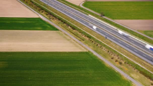 Vista aérea do tráfego em uma estrada entre campos verdes. Prazo de validade — Vídeo de Stock