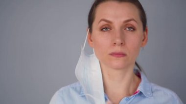 Covid-19 koronavirüsünün pandemik koruması. Tıbbi maske takan beyaz bir kadın. Virüs koruması.