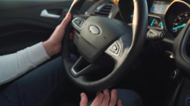 Direksiyon sallayan bir adama yaklaş. Güneş ışığı yan pencereden yansıyor..