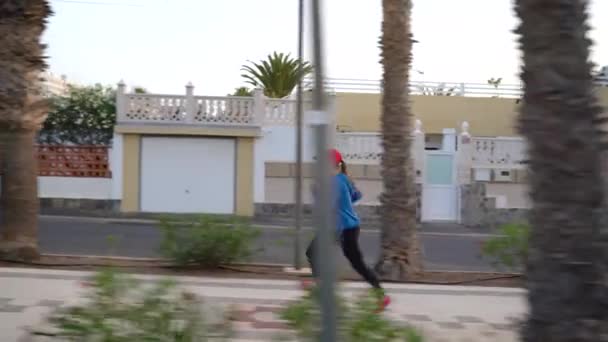 La mujer corre por la calle. Vida activa saludable. Vista lateral — Vídeos de Stock