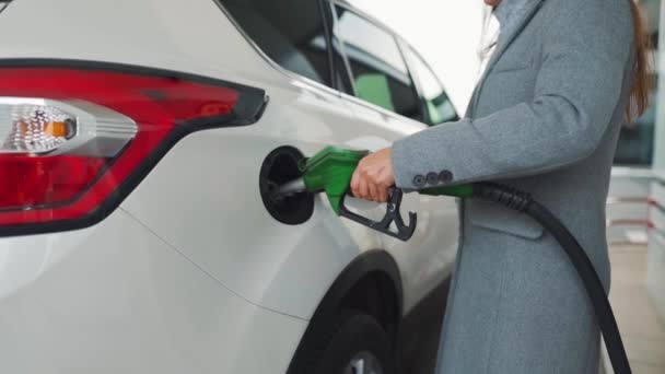 Een vrouw vult benzine in haar auto bij een tankstation. Langzame beweging — Stockvideo