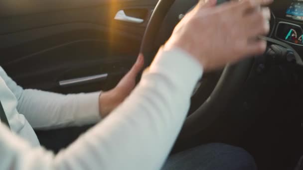 Gros plan d'un homme conduisant une voiture. La lumière du soleil brille par la fenêtre latérale . — Video