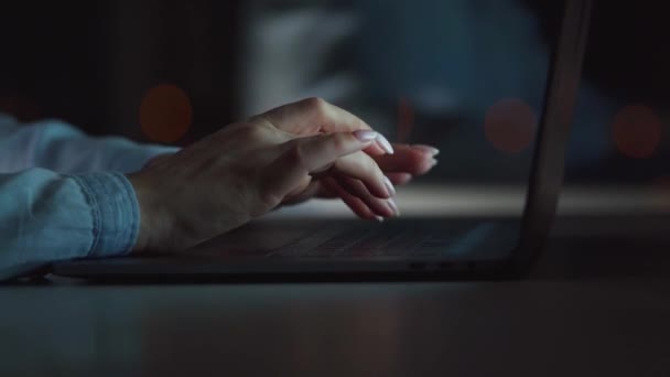 Женские руки печатают на ноутбуке ночью — стоковое видео