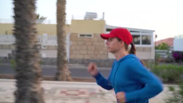 Woman runs down the street. Healthy active lifestyle. Side view — Stock Video