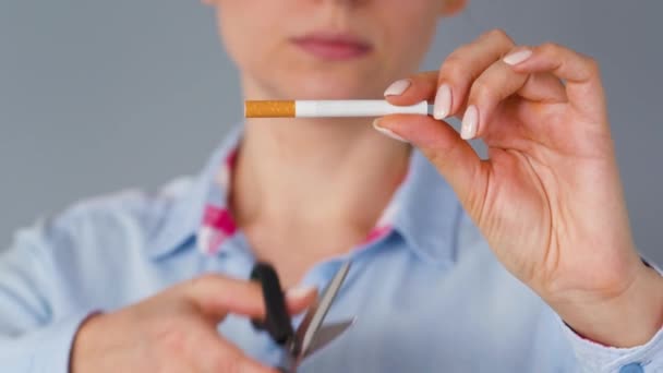 Raucherentwöhnung: Frau schneidet Zigarette mit Schere. — Stockvideo