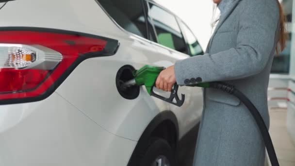 Mujer llena gasolina en su coche en una gasolinera — Vídeo de stock