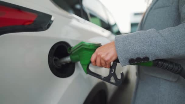 Een vrouw vult benzine in haar auto bij een tankstation. Langzame beweging — Stockvideo