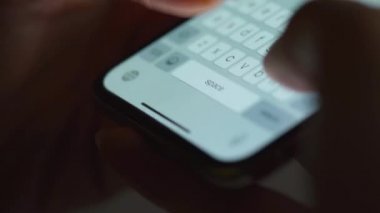Akıllı telefondan yakın planda yazı yazan eller. Akşamları akıllı telefon kullanarak..