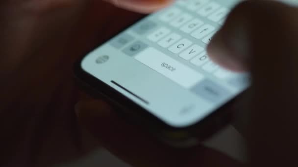 Manos escribiendo texto en el primer plano del smartphone. Usando el teléfono inteligente de cerca por la noche . — Vídeo de stock