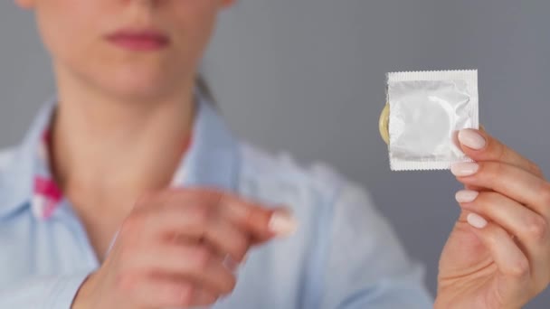 Mains féminines démontrant préservatif devant caméra, sexe sans risque, contraception — Video