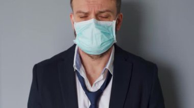 Covid-19 koronavirüsünün pandemik koruması. Tıbbi maske takmış yorgun, beyaz bir adamın portresi. Salgının kavramsal etkisi - işsizlik, yoksulluk, hastalık