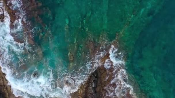 Issız bir sahil manzarası. Tenerife adasının kayalık kıyısı. Okyanus dalgalarının kıyıya ulaştığı hava aracı görüntüleri. Kamera dönüyor. — Stok video