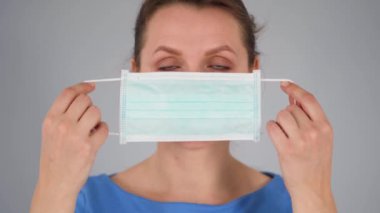 Covid-19 koronavirüsünün pandemik koruması. Tıbbi maske takan beyaz bir kadın. Virüs koruması.