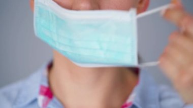 Covid-19 koronavirüsünün pandemik koruması. Tıbbi maske takan beyaz bir kadın. Virüs koruması.