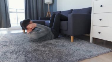 Beyaz adam COVID-19 nedeniyle karantina sırasında karın kaslarını evde çalıştırıyor.