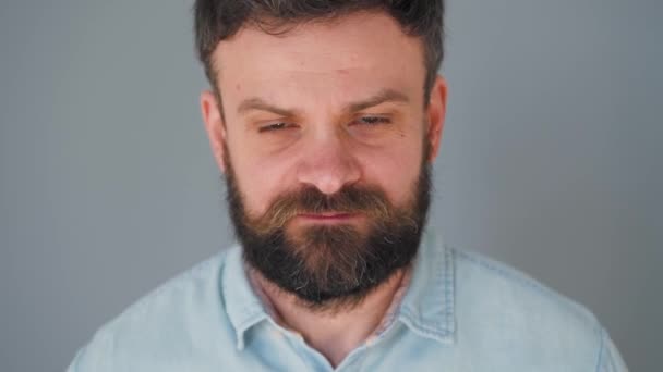 L'homme barbu mâche de la gomme à mâcher et en gonfle une bulle — Video