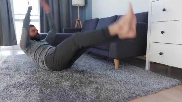 Homem caucasiano treina músculos abdominais em casa durante quarentena devido a COVID-19 — Vídeo de Stock