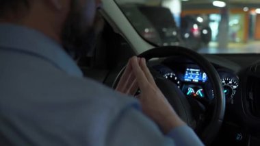 Otomatik otoparkta otopark için otomatik pilot kullanan bir adam yenilikçi bir şekilde araba kullanıyor.