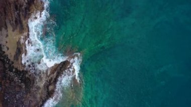 Tenenife adası açıklarında kayalık kıyıya yakın okyanus yüzeyinin üst görünümü, Kanarya Adaları, İspanya. Kıyıya ulaşan deniz dalgalarının havadan drone görüntüleri