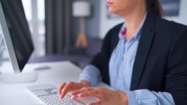 Mujer con gafas escribiendo en el teclado de un ordenador. Concepto de trabajo remoto. — Vídeos de Stock