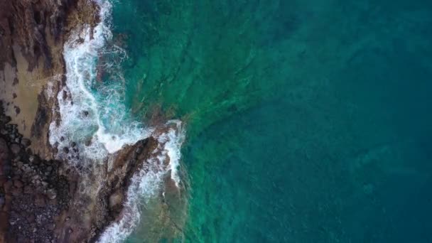 Vista superior da superfície do oceano perto da costa rochosa ao largo da ilha de Tenenife, Ilhas Canárias, Espanha. Imagens aéreas de drones de ondas marinhas que chegam à costa — Vídeo de Stock