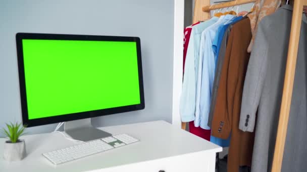 Kreatif studio monitor komputer dengan layar hijau di latar depan. Wanita memilih pakaian di latar belakang. Kunci Chroma. Salin Ruang. — Stok Video