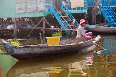 Kamboçyalı kadın bir tekne içinde yüzen