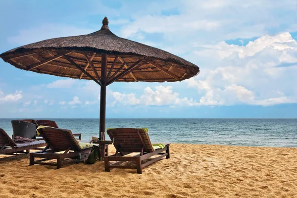 Dřevěné židle a slunečníky na pláži s bílým pískem — Stock fotografie
